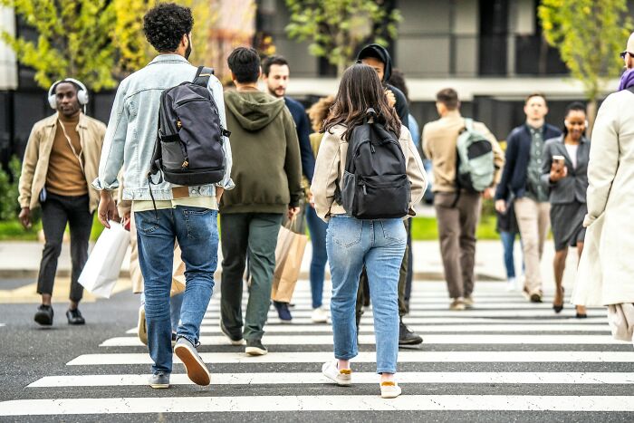 A group of people crossing a street, illustrating things people do that others judge them for.
