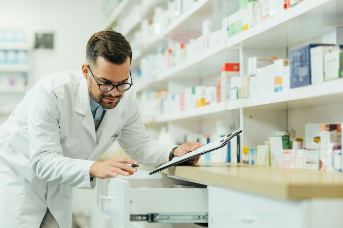 A pharmacist checking inventory in a drawer, highlighting industry insider routines.