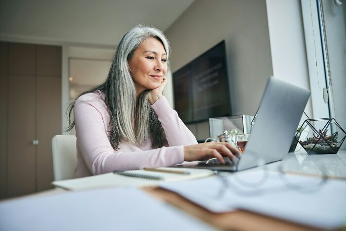 A woman going no contact with a parent, typing on her laptop, finding a new path.