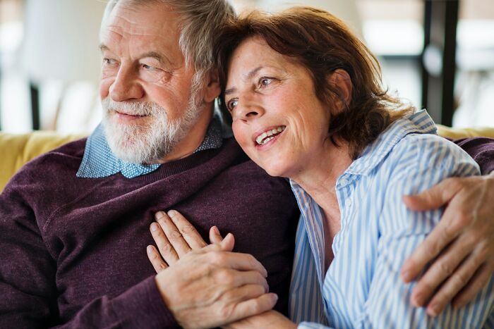 An elderly couple sharing a warm, affectionate moment during a wedding celebration