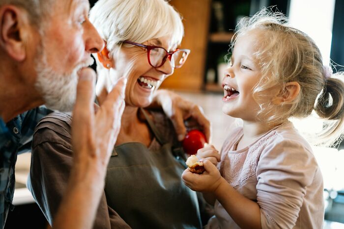 Happy grandparents laughing with their granddaughter, showing family connection despite going no contact with a parent.