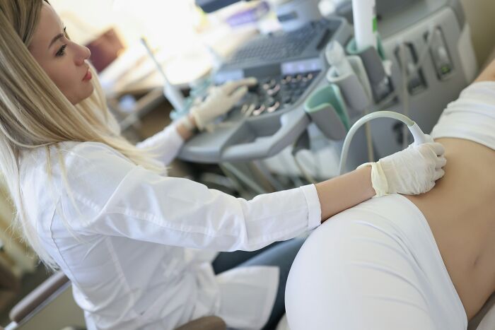 A medical professional performs an ultrasound on a patient, illustrating medical care for extreme illness and sickness.
