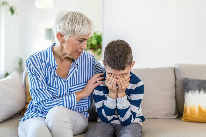 A grandmother comforting a crying child, touching upon the weird and specific nature of childhood beliefs and emotions.