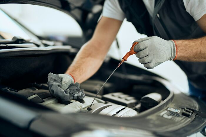 Mechanic checking car oil. This scene highlights things people said without realizing just how ridiculous they sounded.