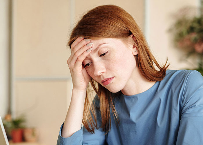 Frustrated nurse holding head in hand, representing a tense moment with her boyfriend. Frustrated nurse holding head in hand, representing a tense moment with her boyfriend.