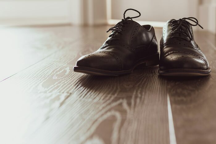 A pair of black leather dress shoes left on the floor by strange patients