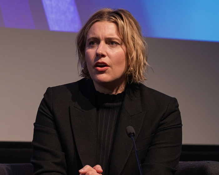 Female director at a panel, facing religious backlash over a fantasy adaptation.