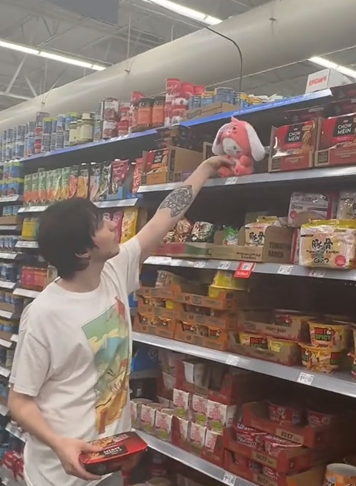 American parents fill the whole cart of groceries. A person reaching for a plush toy on a grocery shelf. American parents fill the whole cart of groceries. A person reaching for a plush toy on a grocery shelf.