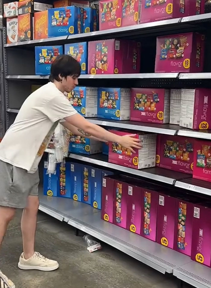 American parents shopping for groceries; person reaching for a large box of snack foods from a grocery store shelf, surrounded by many other snack boxes. American parents shopping for groceries; person reaching for a large box of snack foods from a grocery store shelf, surrounded by many other snack boxes.