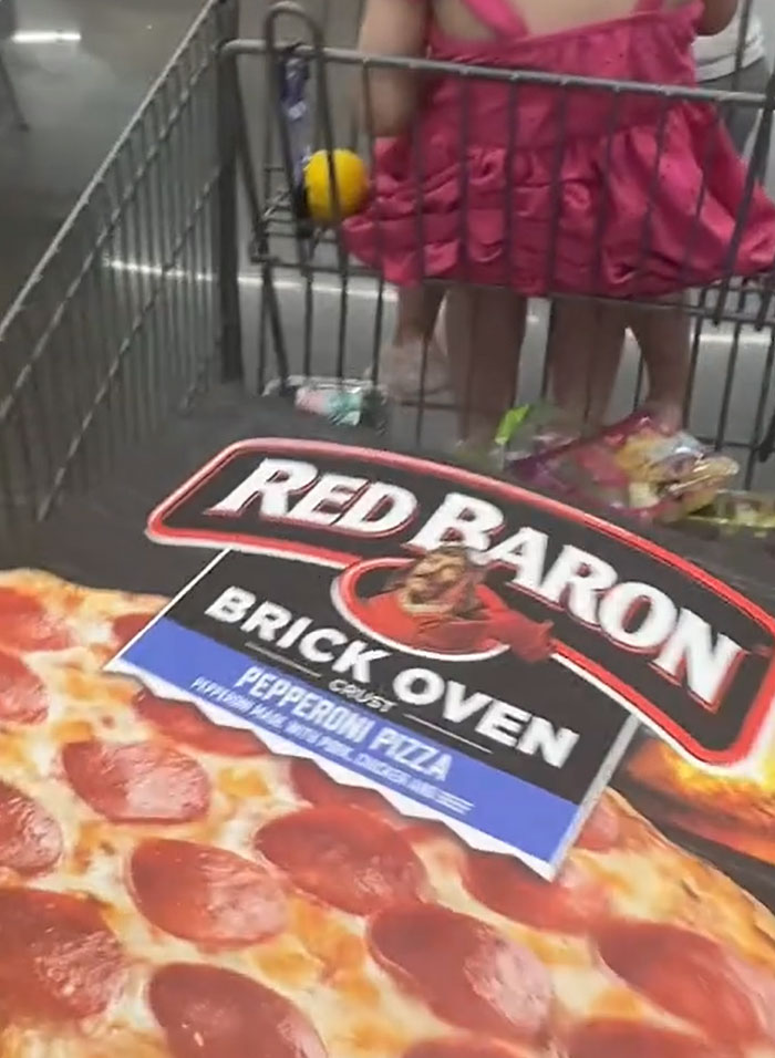 Close-up of frozen pepperoni pizza in a grocery cart, highlighting American parents' grocery choices. Close-up of frozen pepperoni pizza in a grocery cart, highlighting American parents' grocery choices.