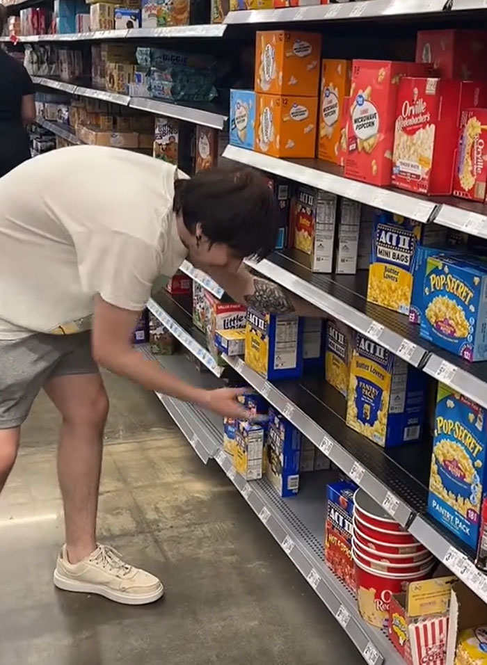 American parents fill grocery cart with boxes of popcorn at the supermarket. American parents fill grocery cart with boxes of popcorn at the supermarket.