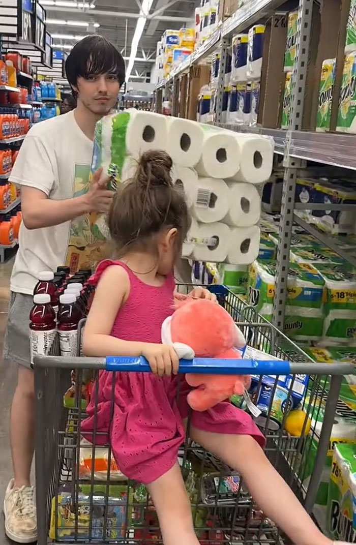 American parents with a full cart of groceries, including a child and paper towels in a store aisle. American parents with a full cart of groceries, including a child and paper towels in a store aisle.