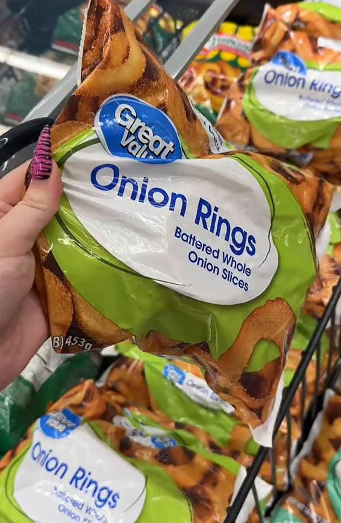 A hand holding a bag of Great Value brand onion rings in a grocery store. Parents buying groceries. A hand holding a bag of Great Value brand onion rings in a grocery store. Parents buying groceries.