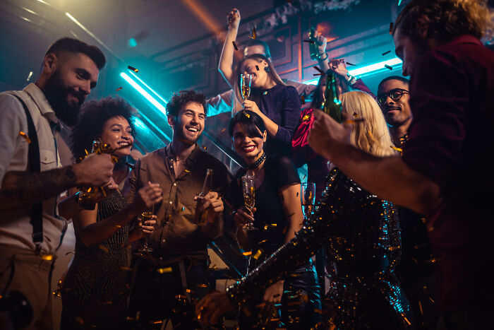 Happy friends celebrating and drinking at a party, avoiding marriage regrets