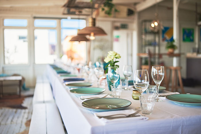 A beautifully set table for a bridal shower, with elegant place settings and soft lighting, emphasizing the generous host's arrangements.