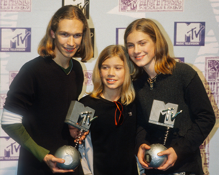 Hanson brothers holding MTV Music Awards trophies at event photo backdrop
