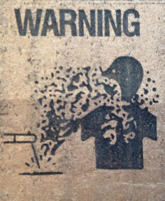 Warning sign showing dissolving silhouette of a person near a liquid spill hazard