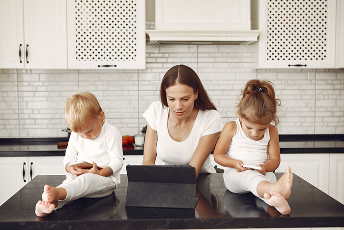 A wife with her two young children, all engaged with electronics, hinting at the wife's hidden money and secret plans. A wife with her two young children, all engaged with electronics, hinting at the wife's hidden money and secret plans.