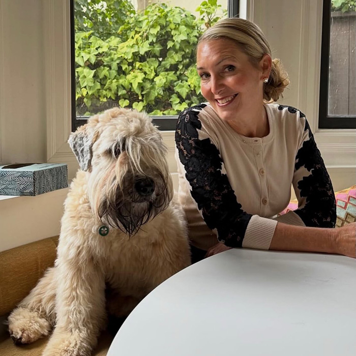 Woman smiles next to large dog indoors amid missing wife search