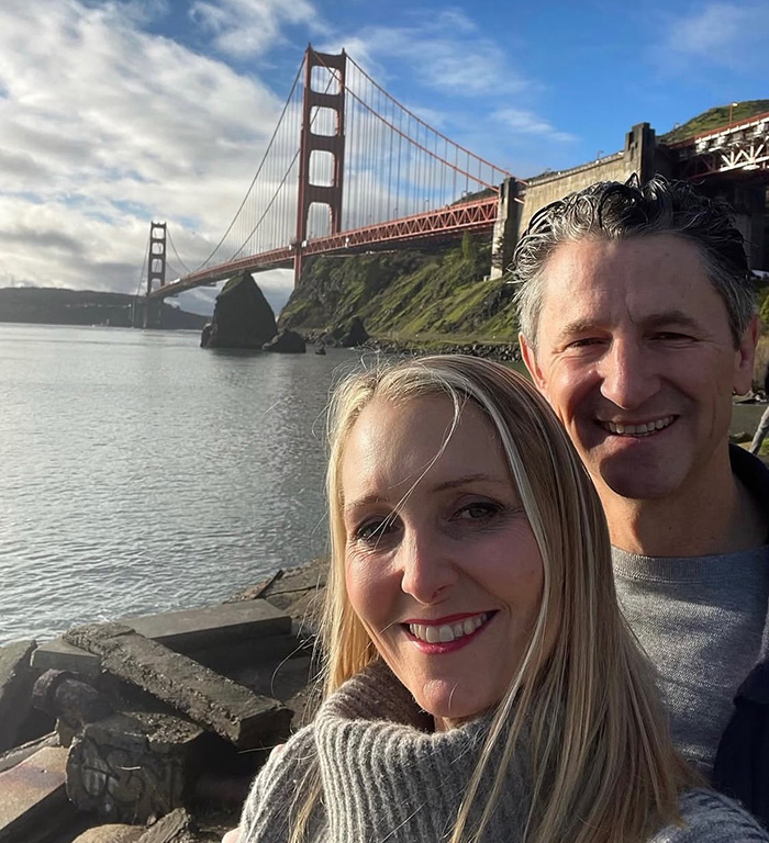 Couple smiling near Golden Gate Bridge in search for missing wife
