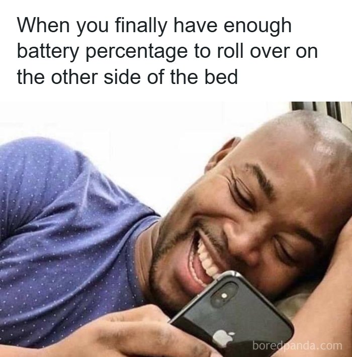 A man laughing while looking at his phone in bed, a hilarious meme about rolling over with enough battery.