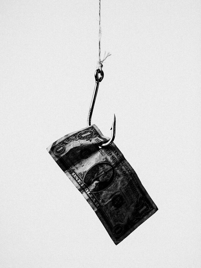 A dollar bill on a fishing hook, a surreal and dystopian image by Marcus Wallinder.