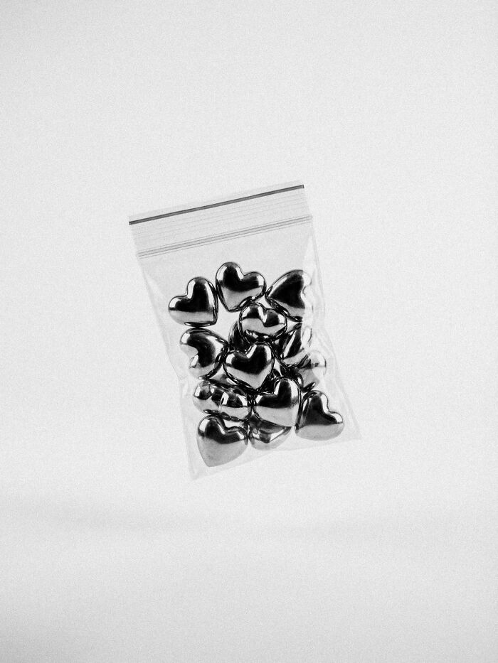 A bag of metallic hearts floating, representing surreal and dystopian images by Marcus Wallinder.