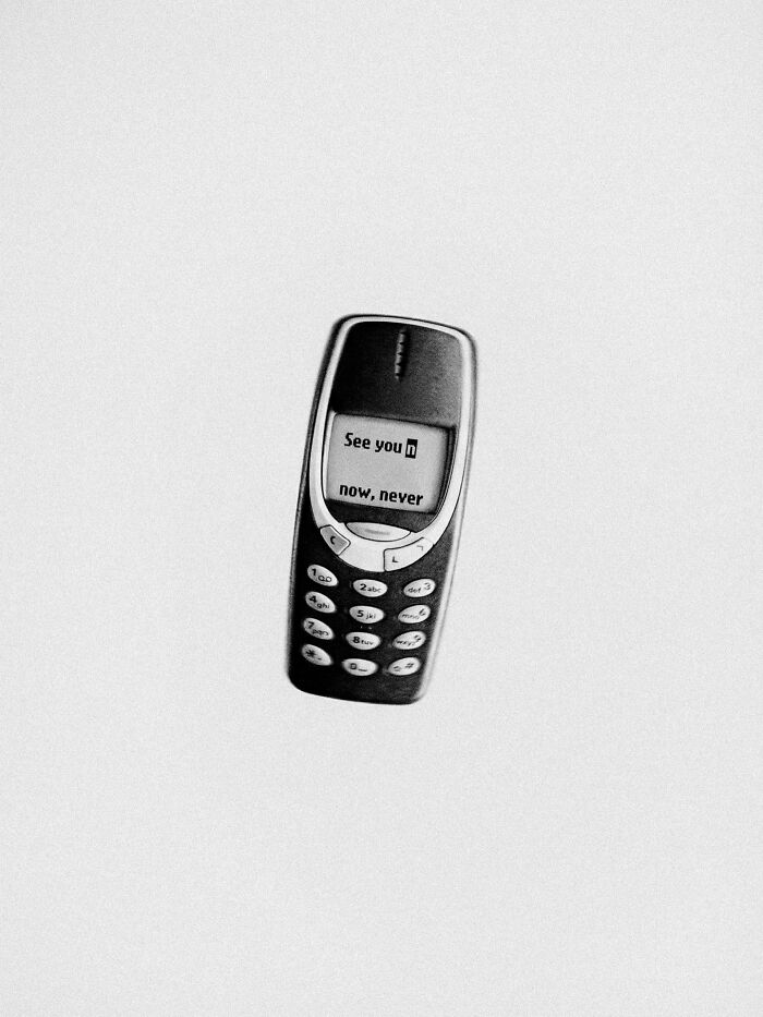 An old mobile phone displaying 'See you now, never' in a surreal and dystopian image by Marcus Wallinder.