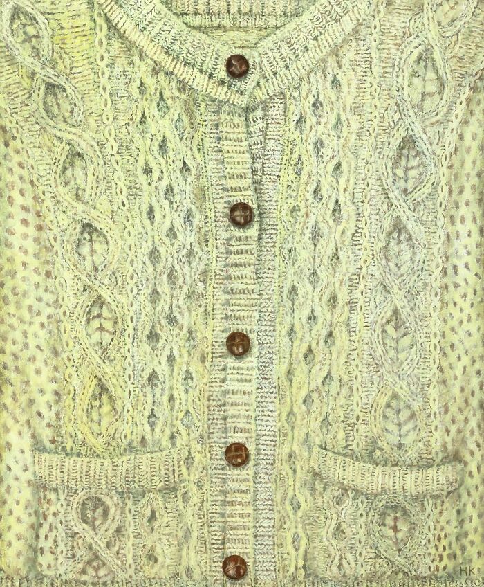 Artist creates striking portrait of identity with a cream-colored, cable-knit jumper featuring wooden buttons and pockets.