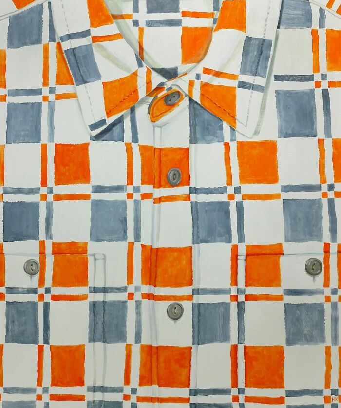 A vibrant jumper with orange and gray plaid patterns, showcasing striking portraits of identity through fabric art.