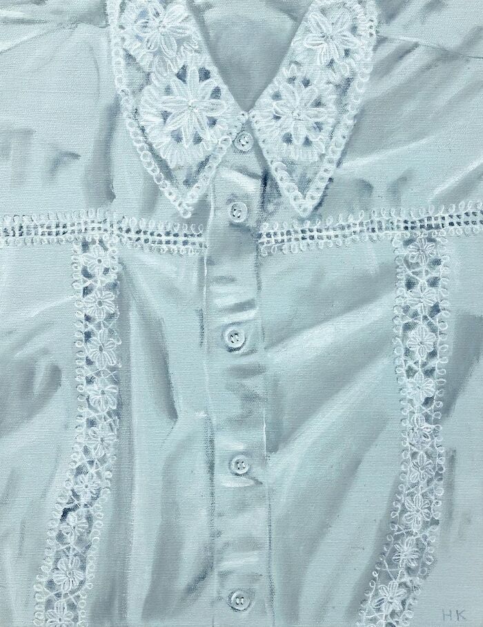 Striking portrait of identity: a white shirt adorned with intricate lace patterns on the collar and front panels.