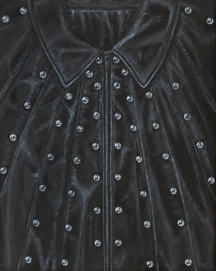 Striking portrait of identity: a black leather jacket with numerous studs and a zippered front.