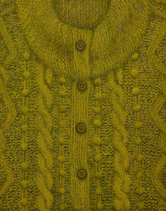 A striking portrait of identity showing a yellow knitted jumper with buttons and a cable knit pattern, by an artist.