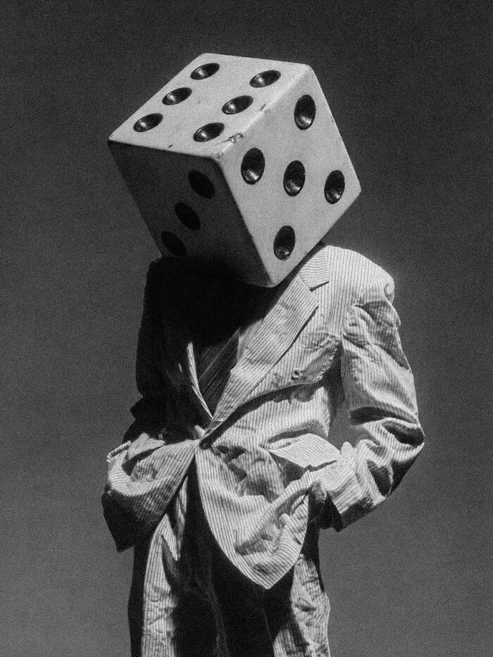 A person with a dice for a head, wearing a pinstripe suit, embodying surreal and dystopian images.