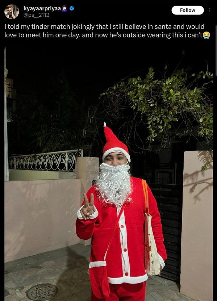 Person dressed as Santa outside, inspired by tinder match, posing with peace sign at night