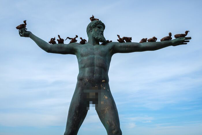 Jeffrey De Keyser's street photography shows a large statue covered with small bird figurines.