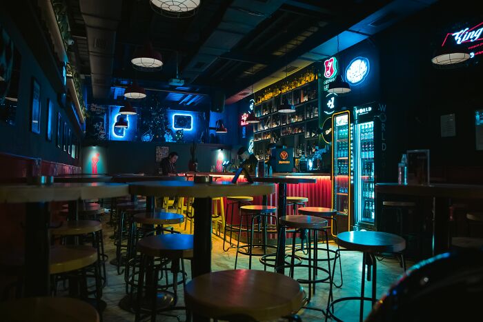 An empty bar with neon lights, symbolizing industries that are about to collapse or face significant decline.