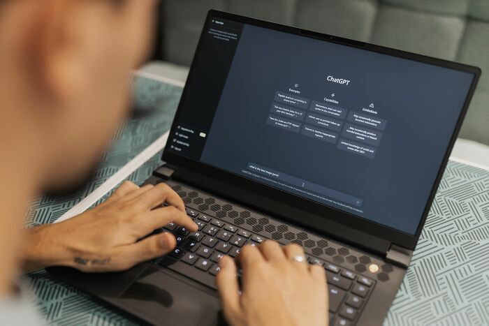 Person using ChatGPT on a laptop, highlighting industries that are about to collapse due to AI advancements.