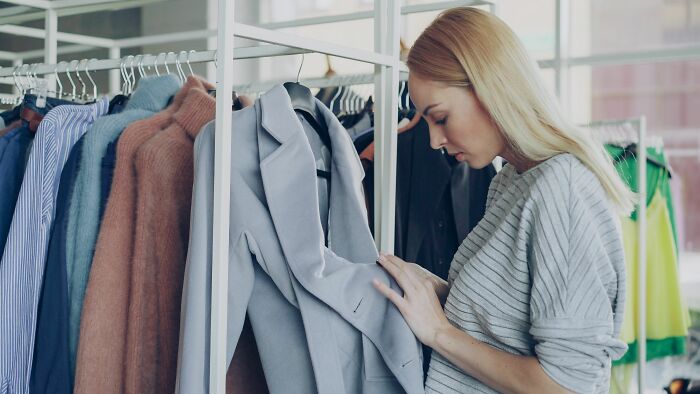 A woman shops for clothes in a boutique, highlighting retail industries about to collapse.