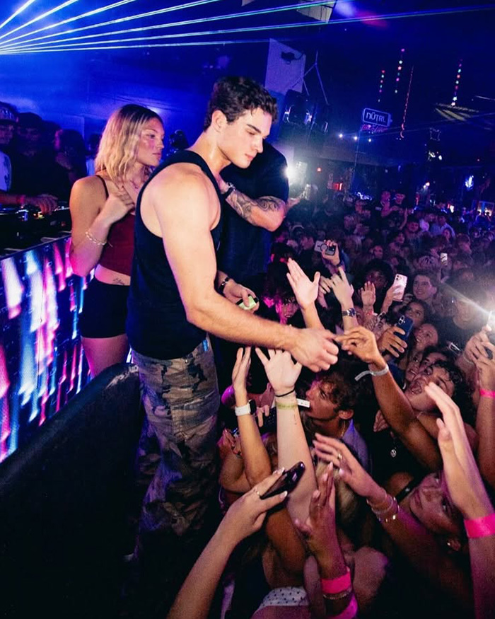 Looksmaxxing Influencer Clavicular reaching out to fans at a crowded nightclub event Looksmaxxing Influencer Clavicular reaching out to fans at a crowded nightclub event