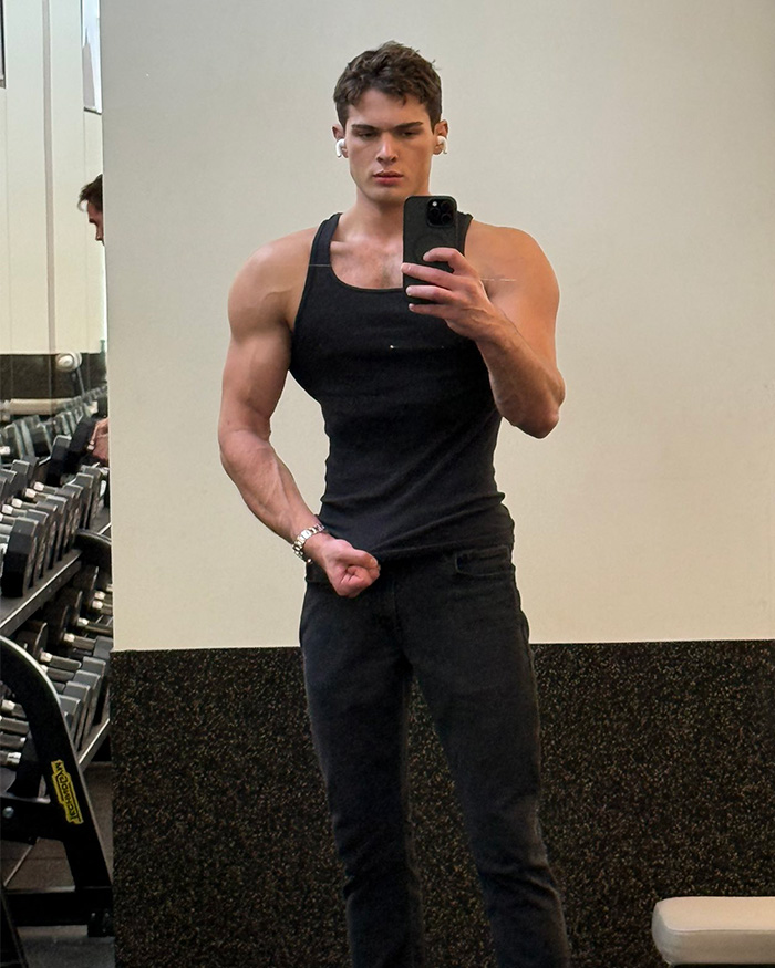 Looksmaxxing Influencer Clavicular taking a mirror selfie in a black tank top at the gym Looksmaxxing Influencer Clavicular taking a mirror selfie in a black tank top at the gym