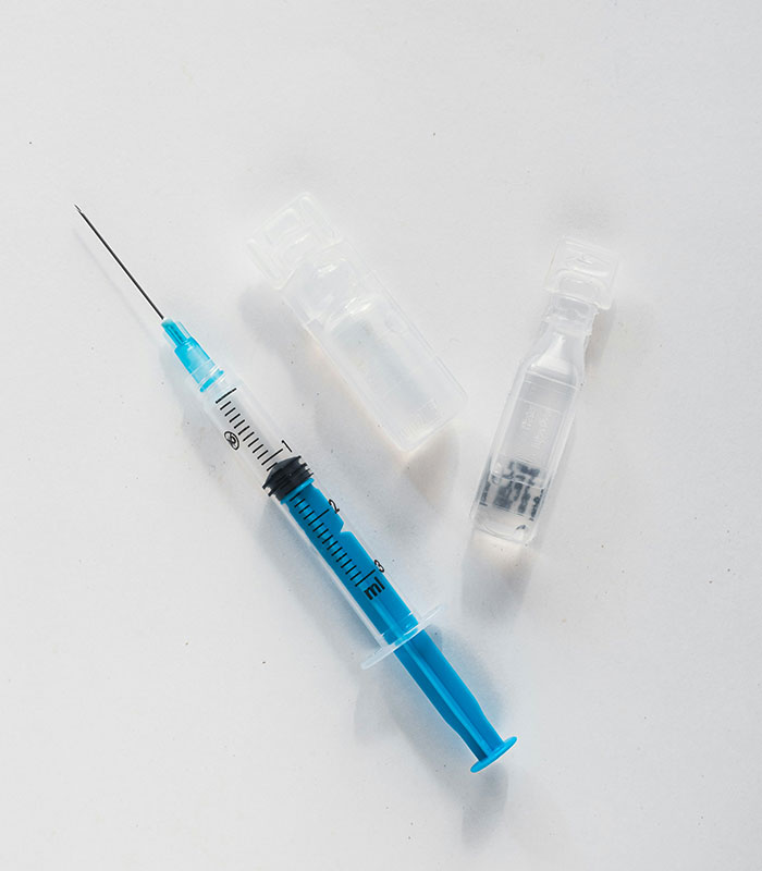 A syringe and two small vials, symbolizing a male cosmetic procedure.
