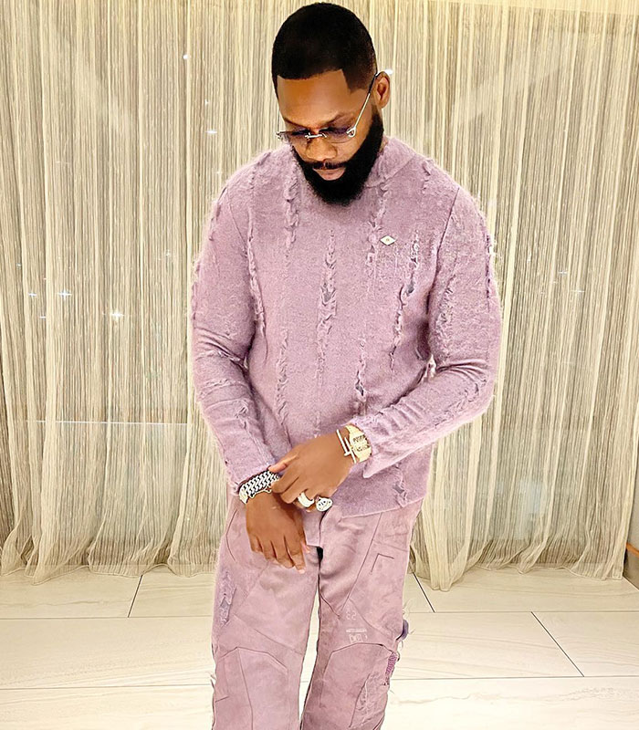 Influencer in a purple outfit, reflecting on the news about a male cosmetic procedure.