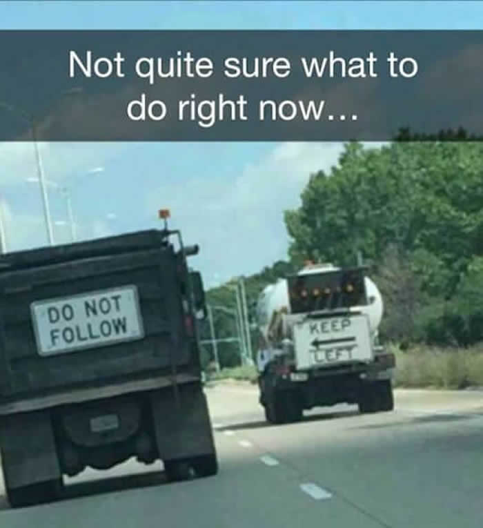 Two trucks on a road, one with a 'Do Not Follow' sign and another with 'Keep Left', creating a synced paradox.