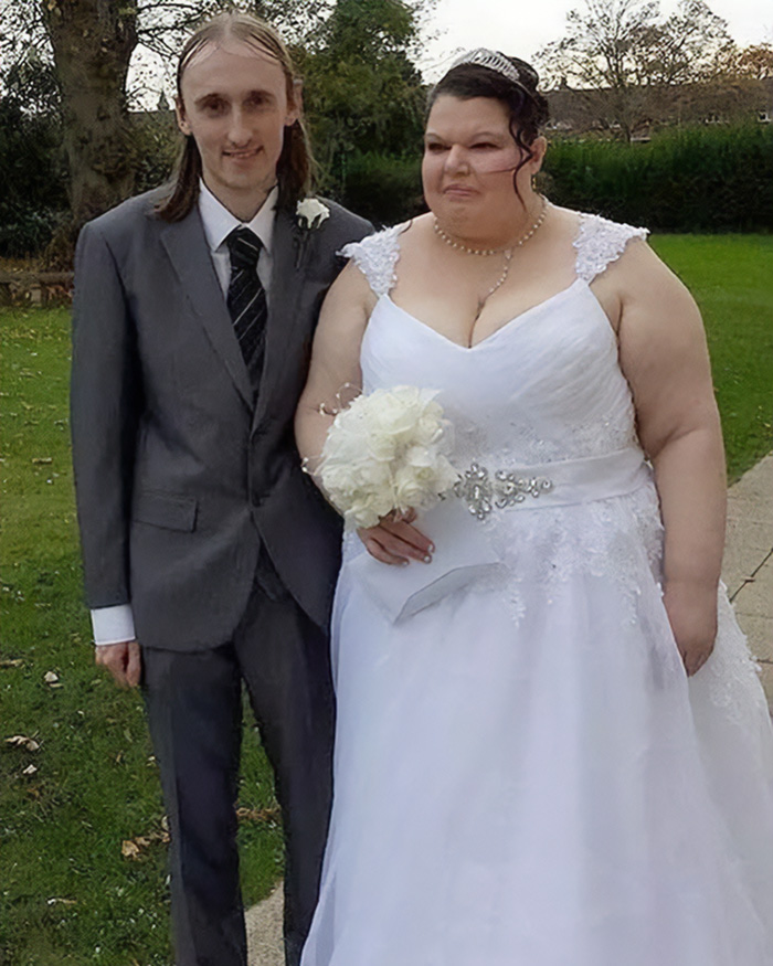 A jealous woman in her wedding dress posing next to her partner in a gray suit A jealous woman in her wedding dress posing next to her partner in a gray suit
