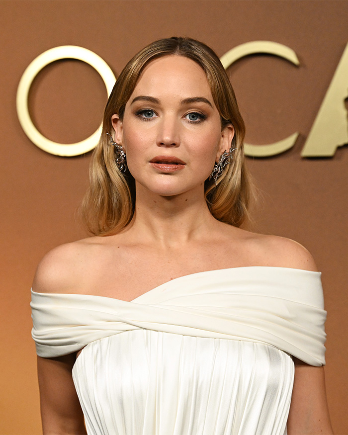 Jennifer Lawrence attends an event, drawing fresh scrutiny after plastic surgery confession.