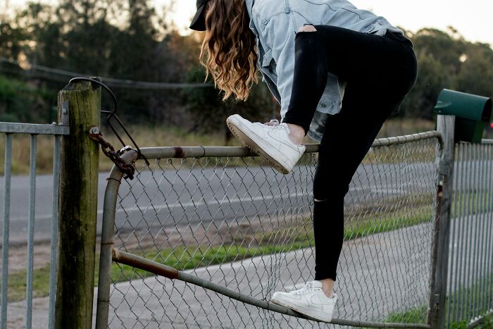 A person climbing over a fence on a first date, perhaps making the first date awkward.