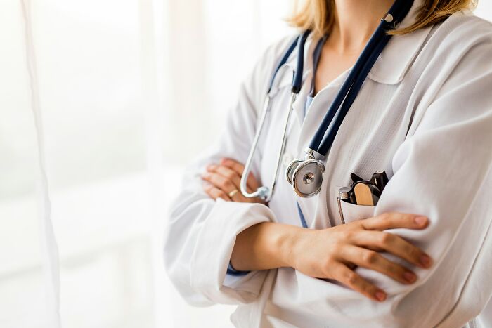 A healthcare worker in a white coat with folded arms, symbolising the current job market.