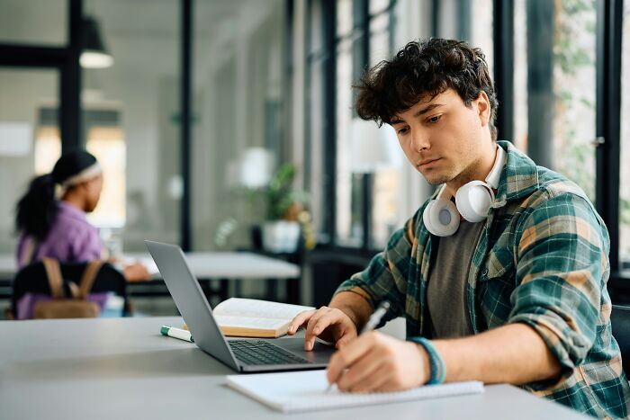Anxious young man looking at laptop, searching for a job on the market
