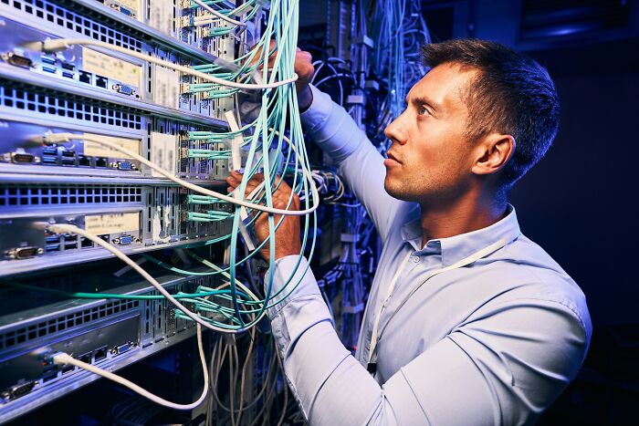IT professional working with complex server cables amid AI industry shifts
